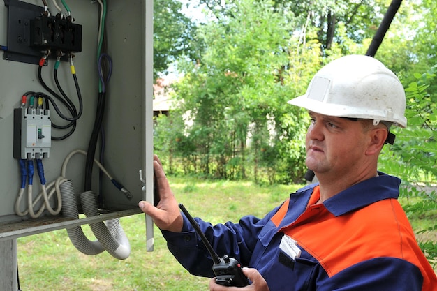 Un ingeniero eléctrico va a apagar el voltaje en el gabinete de control eléctrico.