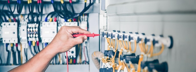 Foto el ingeniero eléctrico comprueba el funcionamiento del armario de control eléctrico. concepto de mantenimiento