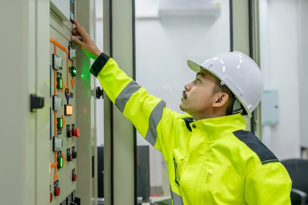 Ingeniero eléctrico verificando voltaje en el gabinete de distribución de energía en la sala de control mantenimiento preventivo Anual Tailandia Electricista trabajando en la empresa