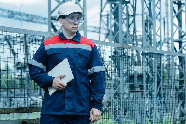 Un ingeniero energético inspecciona los equipos modernos de una subestación eléctrica antes de su puesta en marcha. Energía e industria. Reparación programada de equipos eléctricos.