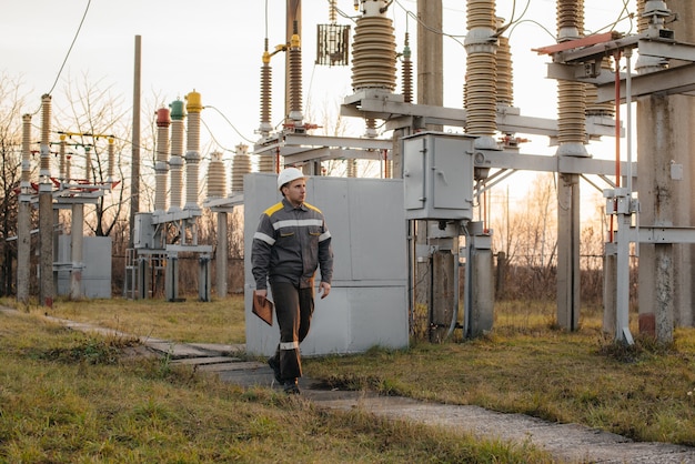 Foto el ingeniero energético inspecciona los equipos de la subestación. ingeniería de la energía. industria