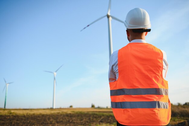 El ingeniero está comprobando la producción de energía en la turbina eólica. Trabajador en el parque de molinos de viento en casco.