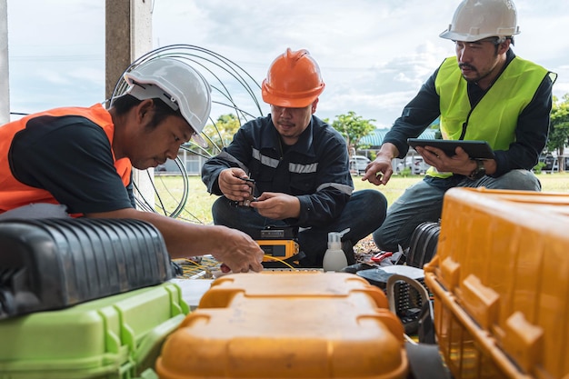 El ingeniero está inspeccionando la conexión de la fibra óptica y el marco de distribución óptica con la máquina empalmadora