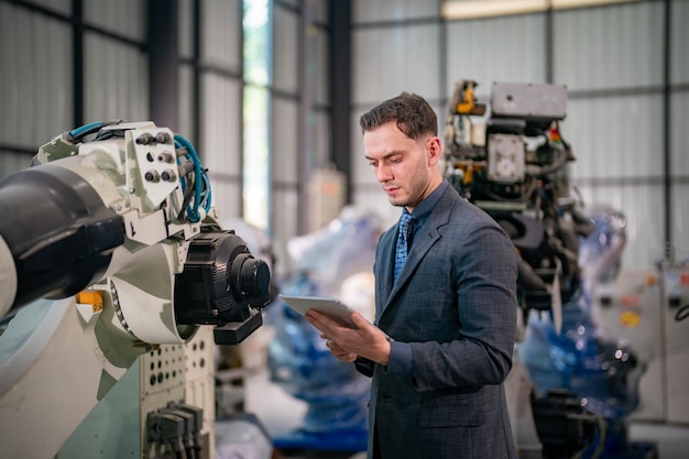 Un ingeniero evalúa máquinas robóticas en una instalación de fabricación moderna