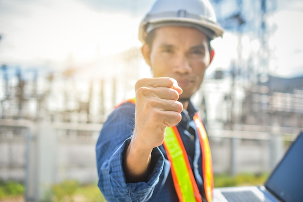 Foto ingeniero con éxito de la mano en el lugar de trabajo