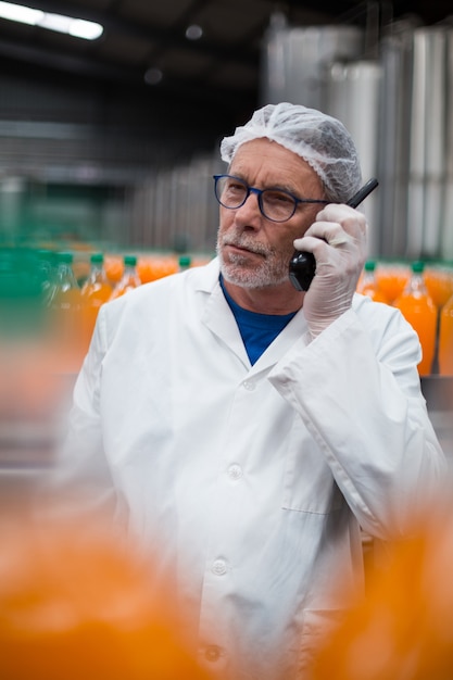 Ingeniero de fábrica hablando por walkie talkie