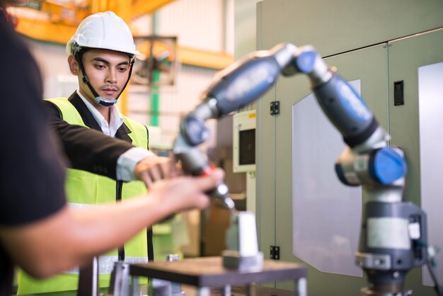 Foto el ingeniero gerente de la fábrica señala con el dedo para controlar el torno automático cnc con la mano del robot