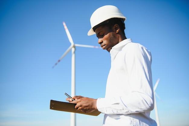 Ingeniero hombre africano de pie con aerogenerador