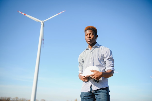 Ingeniero hombre africano de pie con aerogenerador