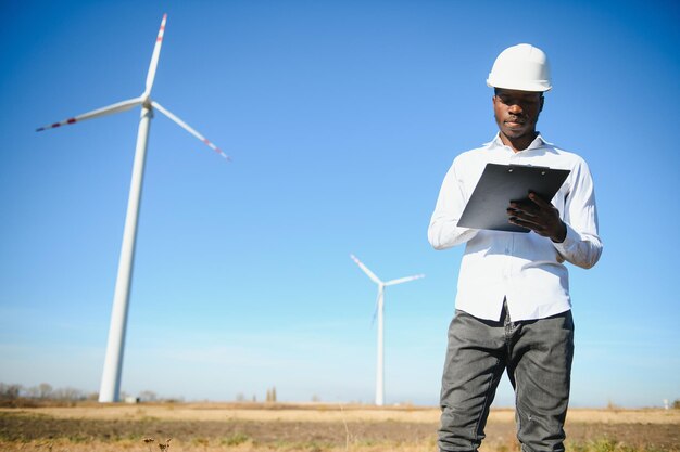 Ingeniero hombre africano de pie con aerogenerador