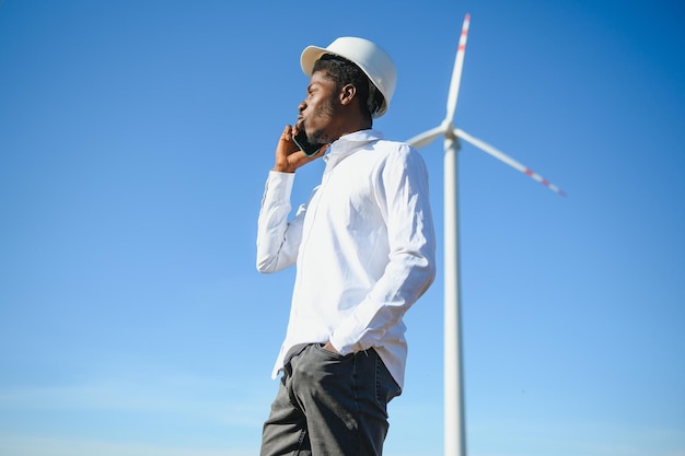 Ingeniero hombre africano de pie con aerogenerador