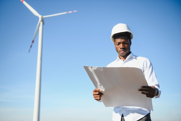 Ingeniero hombre africano de pie con aerogenerador