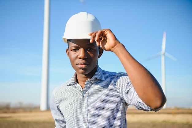 Ingeniero hombre africano de pie con aerogenerador