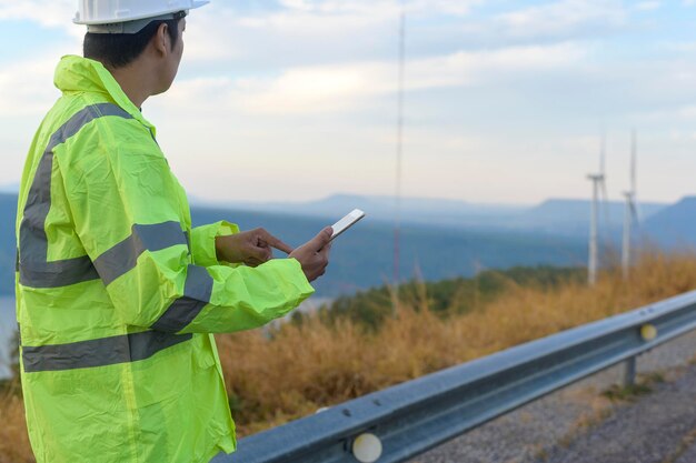 Un ingeniero hombre lleva un casco protector en la cabeza usando tablet Analytics