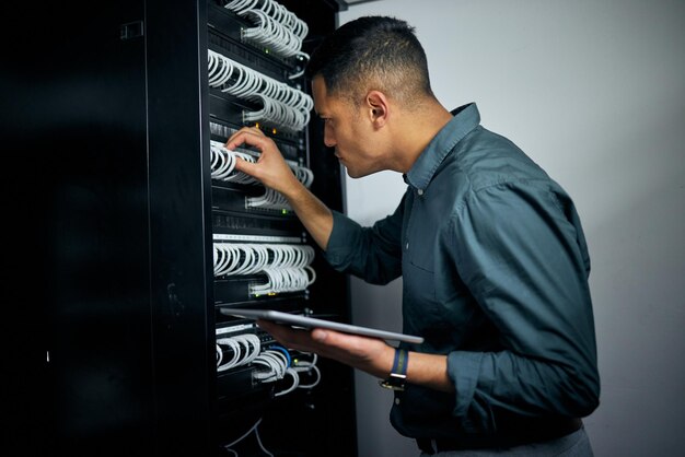 Ingeniero hombre tableta y cables en la inspección de la sala de servidores pensando o comprobando la noche de análisis y la programación Experto en tecnología de la información pantalla táctil o base de datos con mentalidad de resolución de problemas