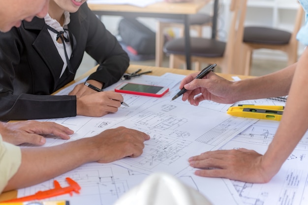 Ingeniero hombre trabajando con dibujos de inspección en el lugar de trabajo