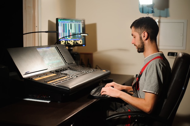 Un ingeniero de iluminación trabaja con técnicos de luces de control en el concierto. Mesa de mezclas profesional, mesa de mezclas. Equipamiento para conciertos.