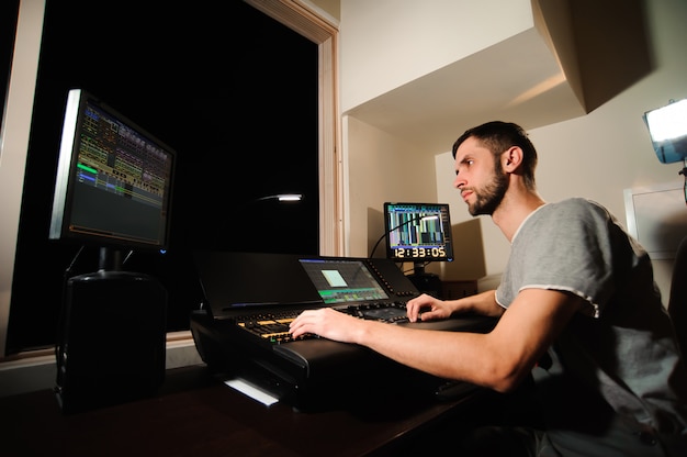 Un ingeniero de iluminación trabaja con técnicos de luces de control en el concierto. Mesa de mezclas profesional, mesa de mezclas. Equipamiento para conciertos