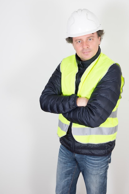 Ingeniero industrial de hombre guapo con casco blanco de chaqueta de seguridad amarilla aislado sobre fondo blanco