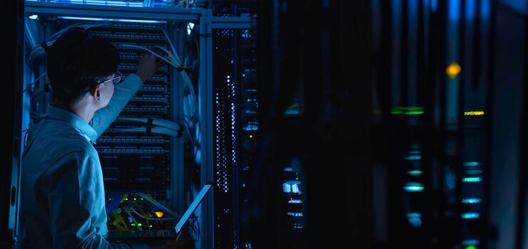 Foto ingeniero informático está configurando la red en la sala de servidores técnico de mantenimiento de sistemas ingeniero masculino trabajando en la habitación de servidores en un centro de datos moderno
