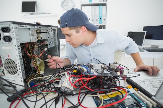 Ingeniero informático que trabaja en la consola rota con la computadora portátil