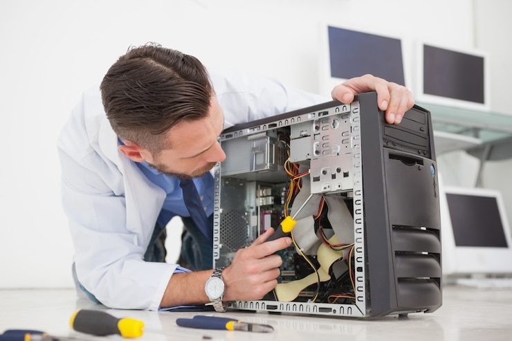 Foto ingeniero informático que trabaja en la consola rota con un destornillador