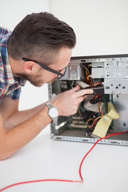 Ingeniero informático que trabaja en la consola rota con un destornillador
