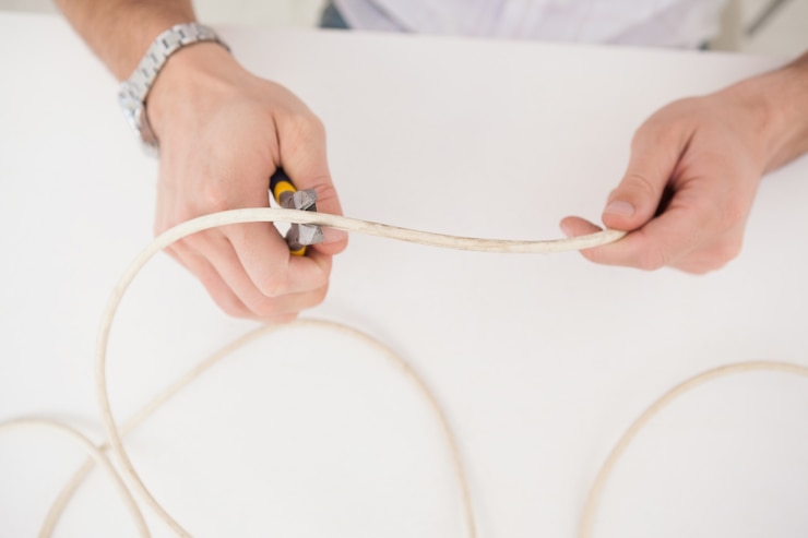 Foto ingeniero informático trabajando en cables rotos.