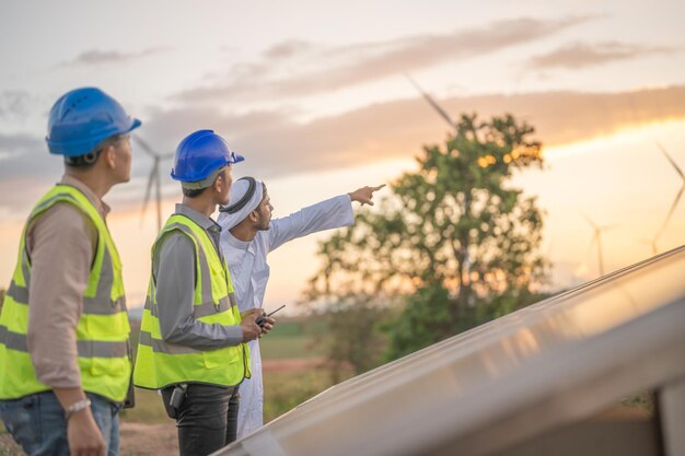 Un ingeniero inspecciona la construcción de un panel de células solares o una célula fotovoltaica mediante un dispositivo electrónico Energía renovable industrial de un trabajador de una fábrica de energía verde que trabaja en el techo de una torre