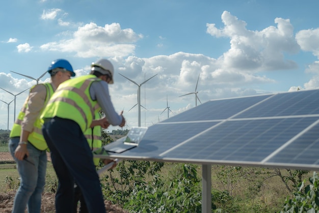 Un ingeniero inspecciona la construcción de un panel de células solares o una célula fotovoltaica mediante un dispositivo electrónico Energía renovable industrial de un trabajador de una fábrica de energía verde que trabaja en el techo de una torre