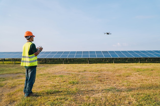 El ingeniero inspecciona y revisa el panel solar de Drone en la planta de energía solar