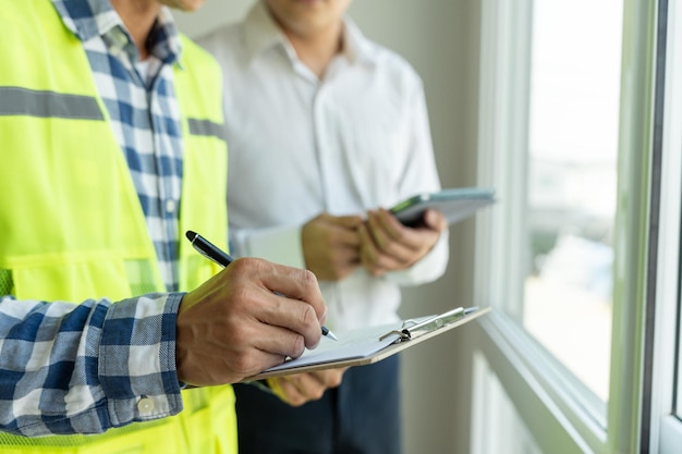 Foto el ingeniero inspector y el propietario del proyecto inspeccionan la construcción y garantizan la calidad de la nueva casa. los ingenieros, arquitectos o contratistas trabajan para construir la casa antes de entregársela al propietario.