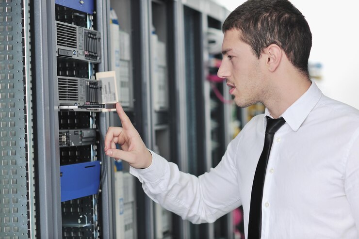Foto ingeniero joven en la sala de servidores del centro de datos
