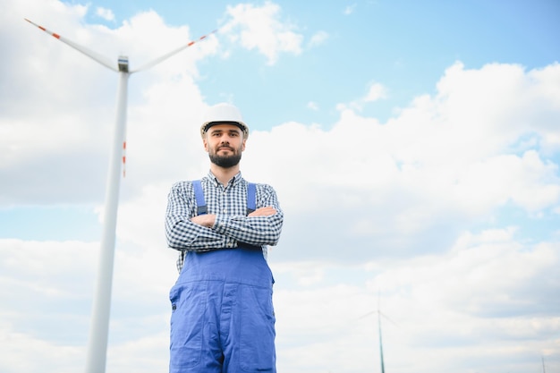 Ingeniero de mantenimiento de turbinas de molinos de viento de pie en el parque eólico