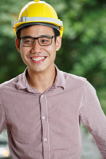 Ingeniero masculino asiático con un casco amarillo