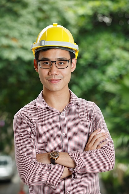 Ingeniero masculino asiático con un casco amarillo