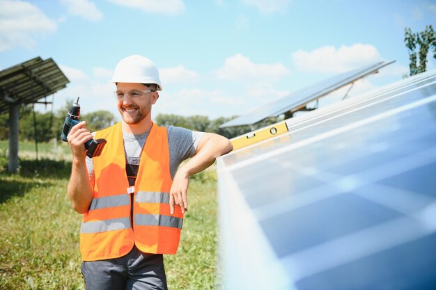 Foto ingeniero masculino en casco protector instalando sistema de panel solar fotovoltaico concepto ecológico de energía alternativa