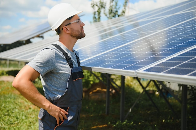 Ingeniero masculino en casco protector instalando sistema de panel solar fotovoltaico Concepto ecológico de energía alternativa