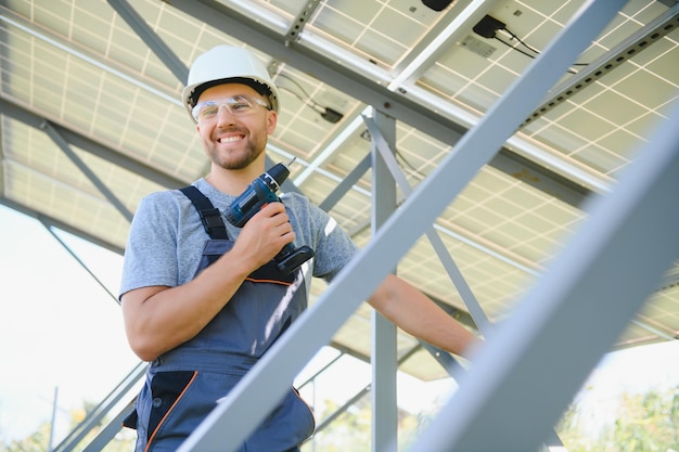 Ingeniero masculino en casco protector instalando sistema de panel solar fotovoltaico Concepto ecológico de energía alternativa