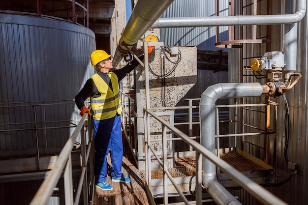 Ingeniero masculino comprobando el tubo de metal en la fábrica.