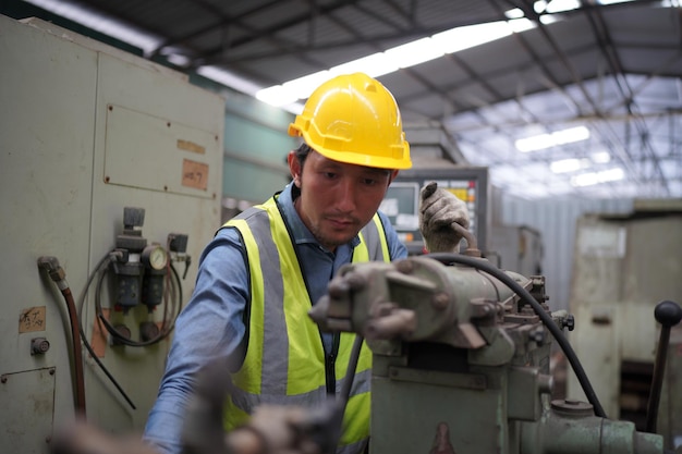 Ingeniero masculino metalúrgico industrial experimentado operador técnico trabajador en casco duro de seguridad trabajando en máquina de torno, hombre profesional en taller de fábrica de fabricación de tecnología industrial