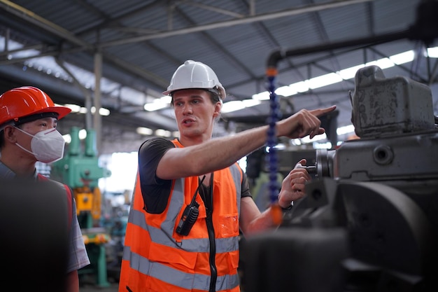 Ingeniero masculino metalúrgico industrial experimentado operador técnico trabajador en casco duro de seguridad trabajando en máquina de torno, hombre profesional en taller de fábrica de fabricación de tecnología industrial