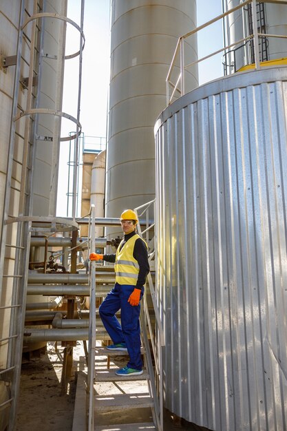 Ingeniero masculino de pie en las escaleras en la fábrica.