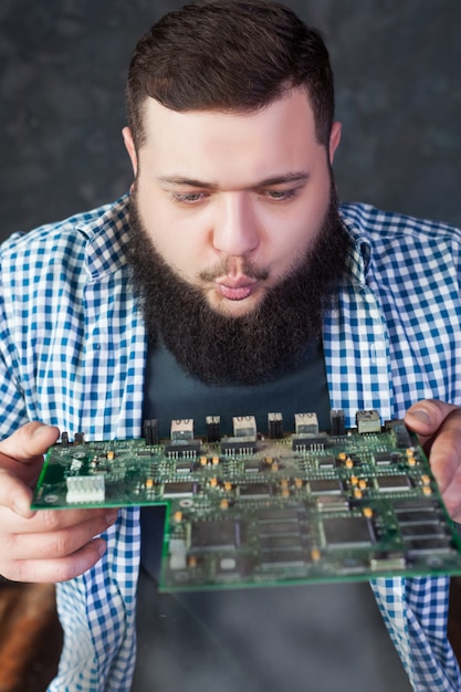 Ingeniero masculino sopla el polvo de la placa base