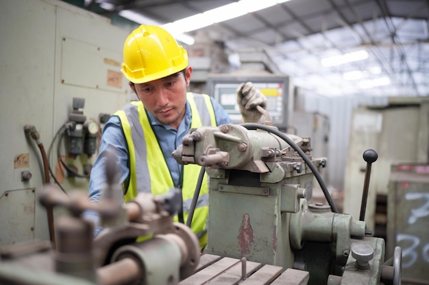 Ingeniero mecánico operando máquina de torno para metalistería en fábrica de metalistería