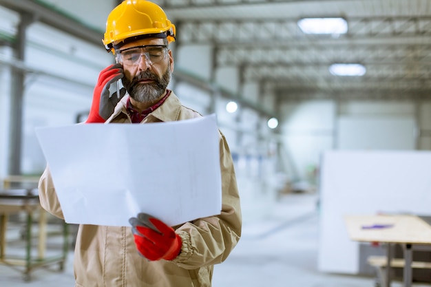 Ingeniero mirando plan en la fábrica