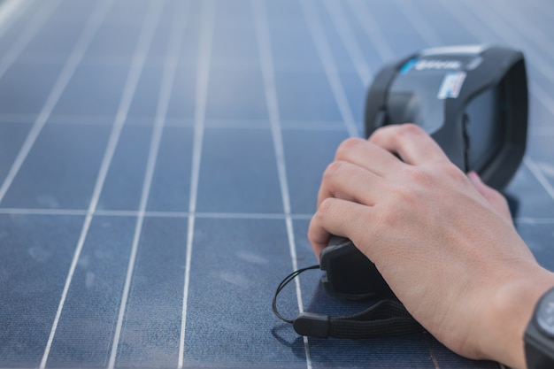 Ingeniero de la mujer usando una cámara termográfica para verificar la temperatura del calor del panel solar