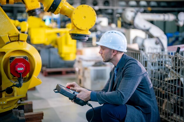 Ingeniero opera un brazo robótico en una instalación industrial durante el día
