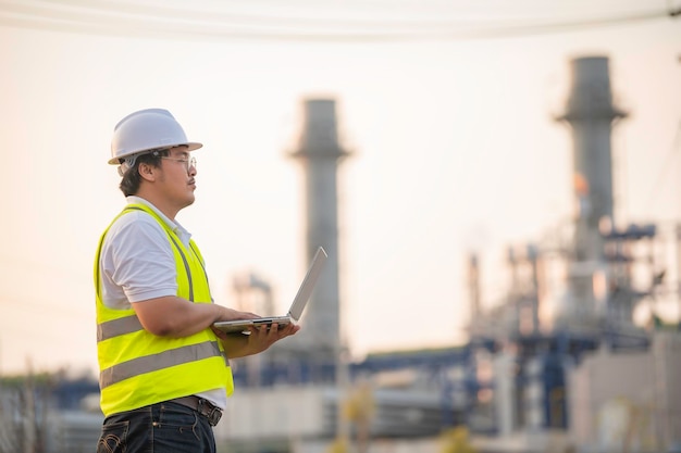 Ingeniero petroquímico asiático que trabaja en la fábrica de la industria de plantas de refinería de petróleo y gas