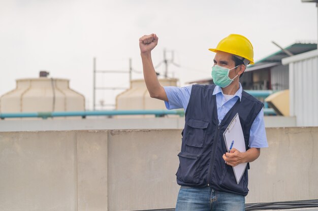 Ingeniero de pie en el techo del edificio de producción Mostrar compromiso y éxito